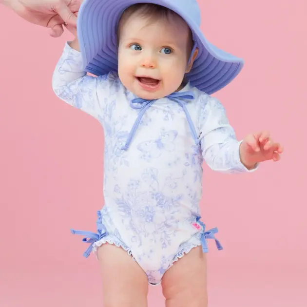 Costume intero rash guard a manica lunga per bambina, colore pervinca, fantasia giardino di farfalle, con i caratteristici volant sul retro