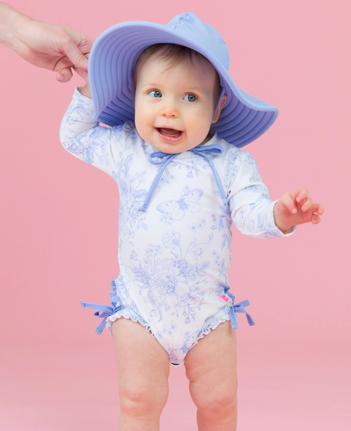 Costume intero rash guard a manica lunga per bambina, colore pervinca, fantasia giardino di farfalle, con i caratteristici volant sul retro